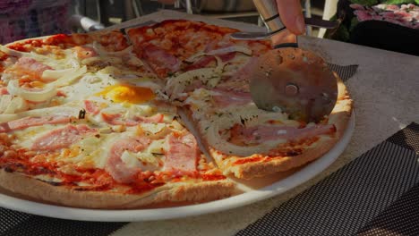 slicing delicious fresh pizza in restaurant, close up view