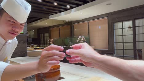 el chef presenta sushi a un cliente
