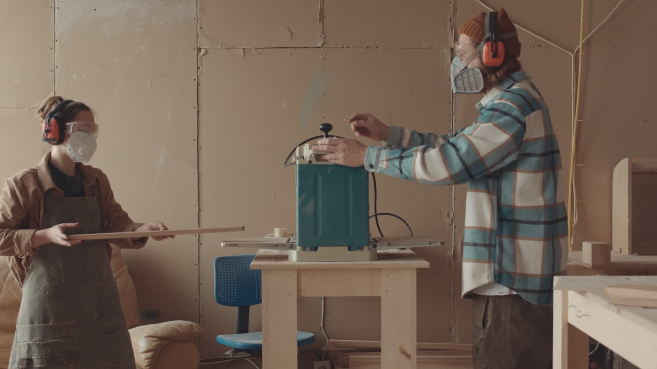 Two Carpenters Working Together in Workshop