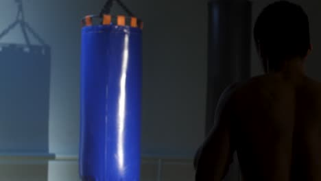 hombre entrenando con saco de boxeo