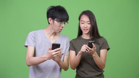young asian couple using phone together