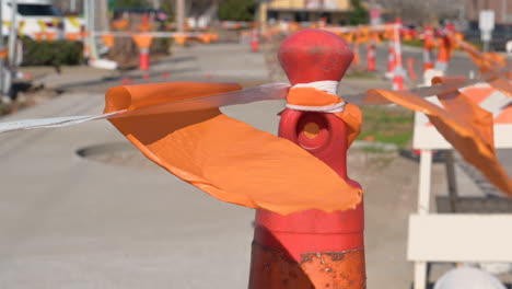 banderas naranjas soplando por el viento atadas en las cuerdas en la cerca de conos con cinta rayada para separar la carretera mientras se renueva el tiempo, la seguridad es la primera señal de tráfico