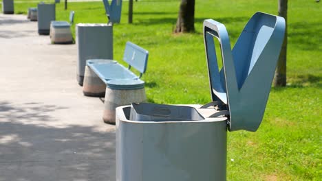 open trash can and park benches