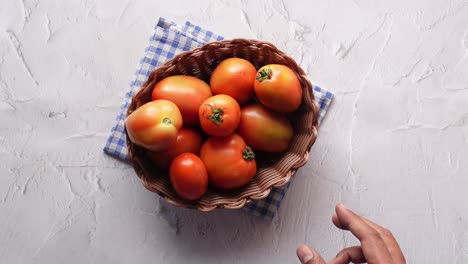 hand of person picking tomatoes from a bowl