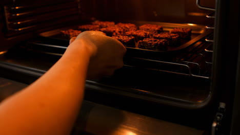 mujer llevando galletas en una hoja de hornear