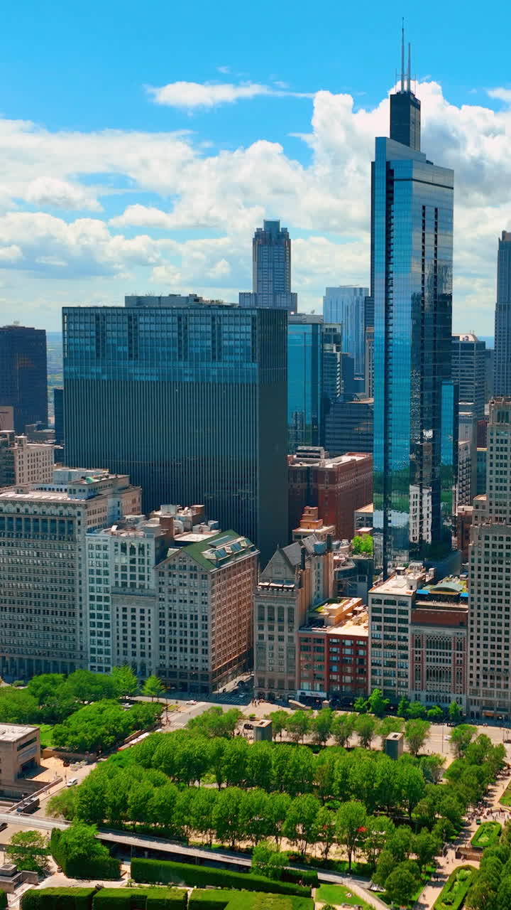 Modern architecture in downtown Chicago. Aerial view from Millennium Park with green lawns and trees to tall glass skyscrapers. Willis Tower