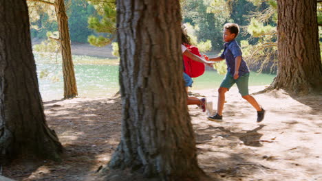 Niños-Corriendo-Delante-De-Sus-Padres-En-Una-Aventura-De-Senderismo-Familiar.