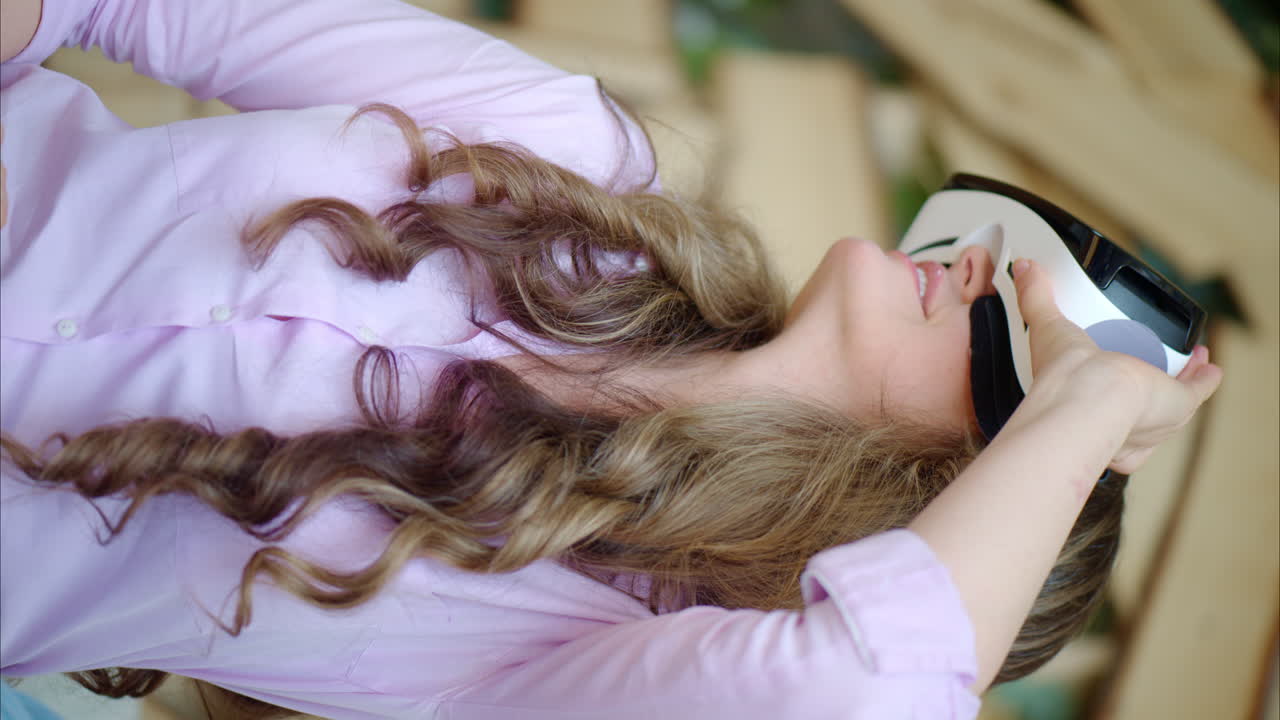 Woman putting on VR headset and enjoying it. Vertical