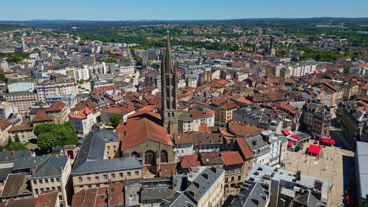 Drone ad alta quota che effettua una panoramica laterale sul centro della città di Limoges, concentrandosi sulla basilica di Saint-Michel-des-Lions, circondata da fitti tetti e strade urbane - Francia