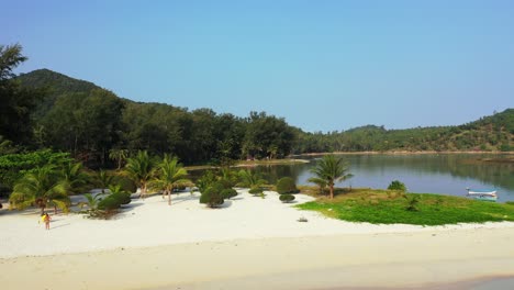 Wunderschöner-Ferienresort-Garten-Mit-Palmen,-Die-Auf-Dem-Weißen-Sand-Der-Küste-Einer-Tropischen-Insel-Gepflanzt-Sind-Und-Vom-Ruhigen,-Klaren-Wasser-Des-Hafens-In-Thailand-Umspült-Werden