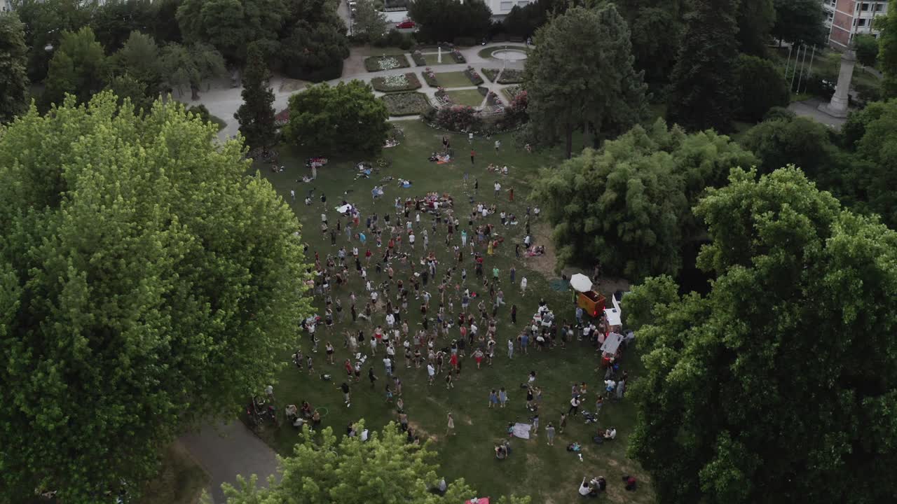 discoteca silenciosa en el parque, freiburg im breisgau alemania bailando con la música toma aérea 4k cinemática