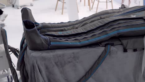 inflatable leg compression garment displayed on padded table in clinic