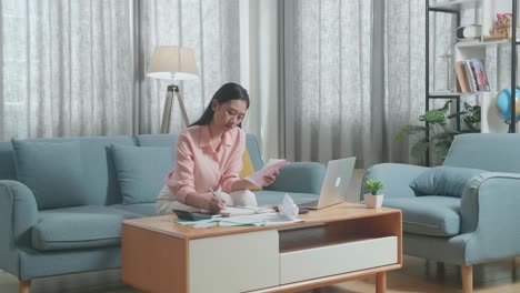 노트북 에 비용 을 기록 하고 빌 을 보고 있는 노트북 을 가진 아시아인 여자