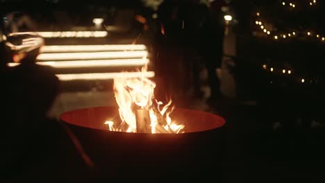 Gente-Parada-Alrededor-De-Una-Fogata-Durante-Navidad-En-El-Mercado-De-Navidad