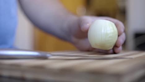 static shot of a man peeling an onion