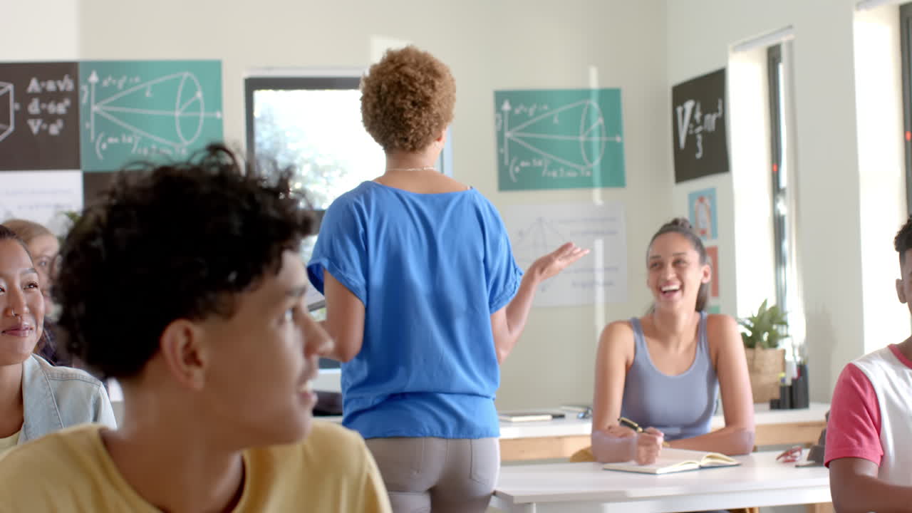 In high school, teacher explaining math concepts to students in classroom