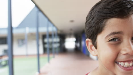 En-El-Pasillo-De-Una-Escuela,-Un-Joven-Estudiante-Caucásico-Sonríe-Cálidamente-Con-Espacio-Para-Copiar