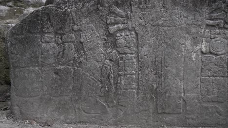 detailed carvings on a stone slab showcase ancient mayan artistry and symbols. the artwork features figures and hieroglyphs, revealing the culture's rich history and craftsmanship.