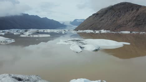 vuelo bajo de drones sobre lago glacial y hielo flotante - skalafellsjökull, islandia