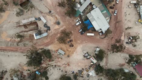 a high view looking down at a old pub and discarded mining equipment in the australian outback of a small mining town in the opal capital of the world lightning ridge