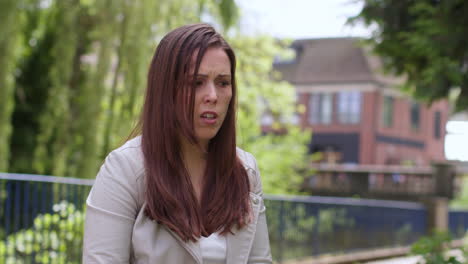 close up of depressed woman outdoors with financial worries about cost of living crisis debt and paying bills in city park