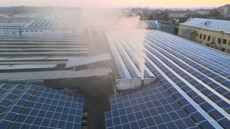 aerial view of solar power plant with blue photovoltaic panels mounted on industrial building roof for producing green ecological electricity. production of sustainable energy concept