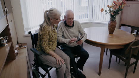 elderly couple looking at a tablet indoors