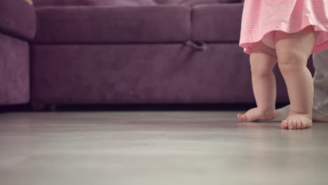 los pies del niño caminando por el suelo. los pies del bebé pisando en casa. el primer paso del niño