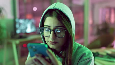 woman looking at phone in a night office