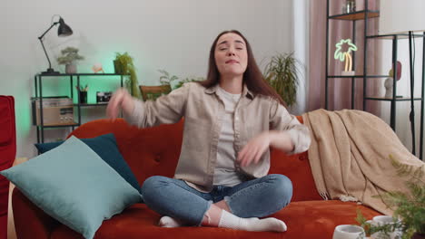 mujer alegre y positiva de moda bailando y moviéndose al ritmo haciendo un gesto de baile dub en el hogar moderno