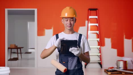 trabajador de la construcción usando una tableta en un trabajo de pintura.