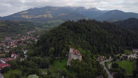 Seitwärts-Verfolgende-Drohnenaufnahme-Der-Burg-Bran-Im-Stadtbild-Von-Brasov-In-Rumänien