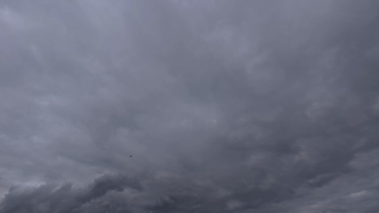 Time-lapse of thick clouds forming and darkening the sky before rainfall. Transition from bright to stormy atmosphere