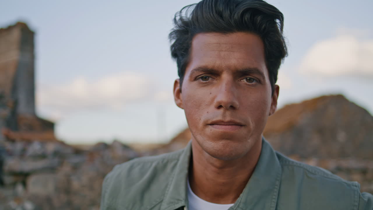 hombre guapo sonriendo cámara en el retrato de paisaje de verano. hombre posando en el pueblo