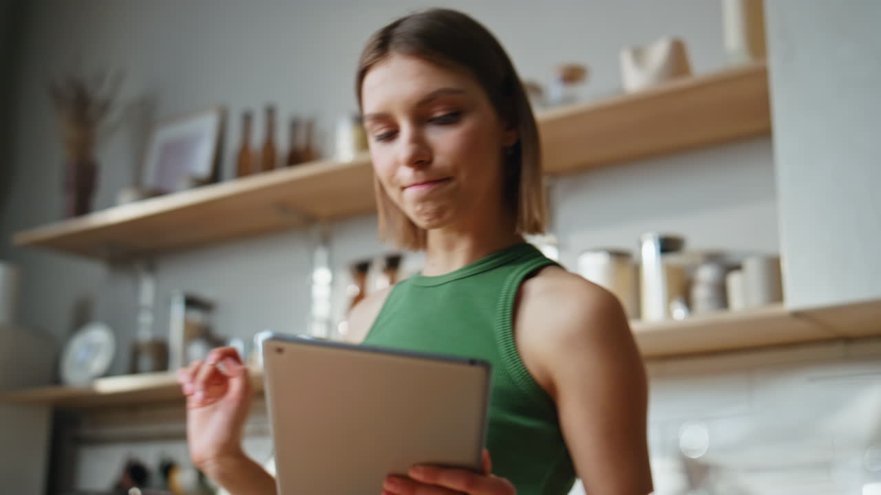 mujer usando tableta en la cocina