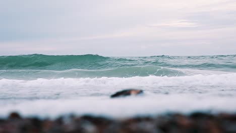 Sea-birds-flying-over-big-ocean-waves-crashing-viewed-from-cliff-above