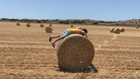 hombre subiendo a la bola de rodillos en el campo abierto