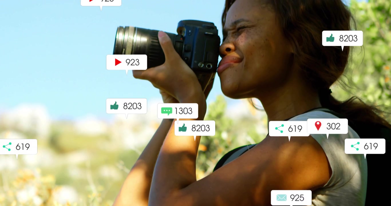 Female shooter raising DSLR, pressing shutter, spawning badges around lens and torso for marketing