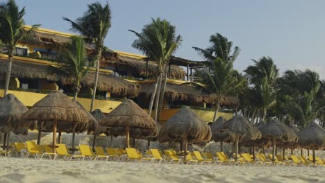 tiki huts and deckchairs sit abandoned on hotel beach during covid 19 lockdowns