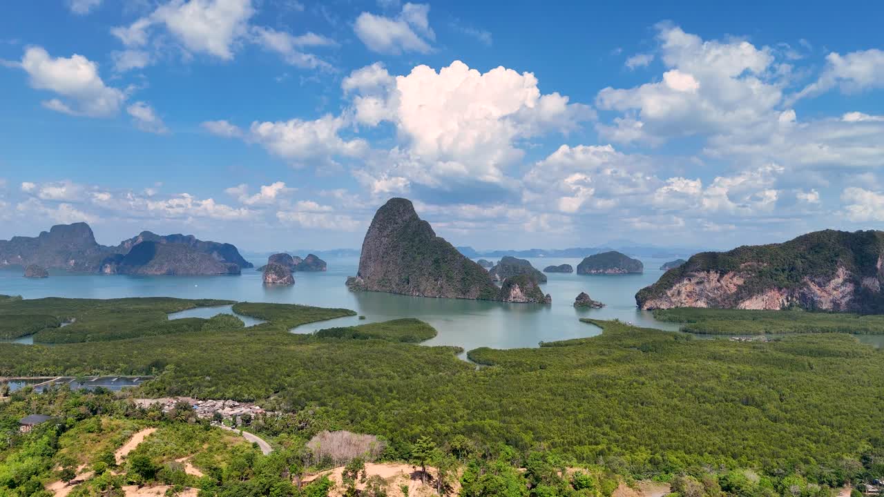 Drone footage captures the stunning limestone formations and lush greenery of Phang Nga Bay, Thailand, under bright daylight