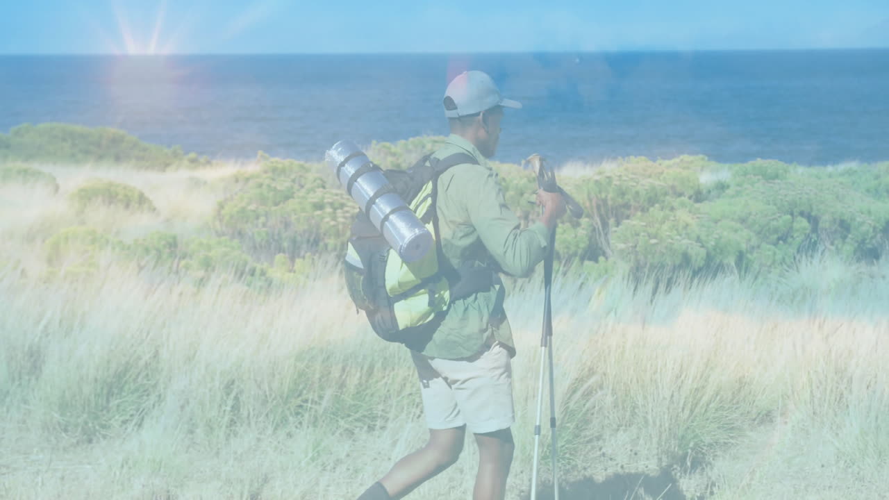 Man adjusting hiking poles on coastal dune trail, showing animated route map and health chart