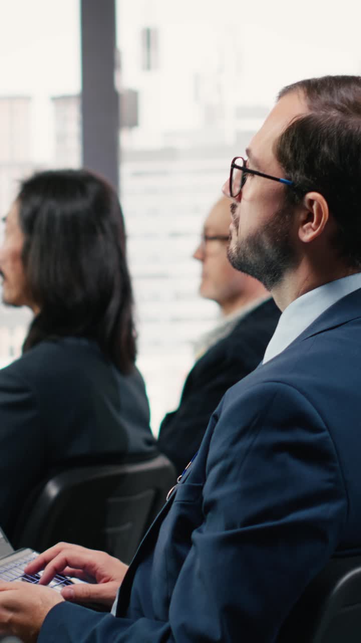 Un consulente di Vertical Video Business prende appunti su un laptop durante un evento di una conferenza internazionale