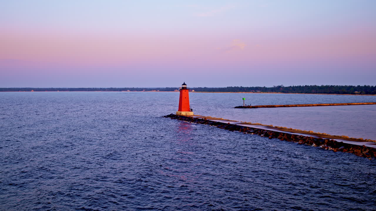 Drone shot flying over lake Michigan towards the lighthouse and breakwater near Manistique Michigan