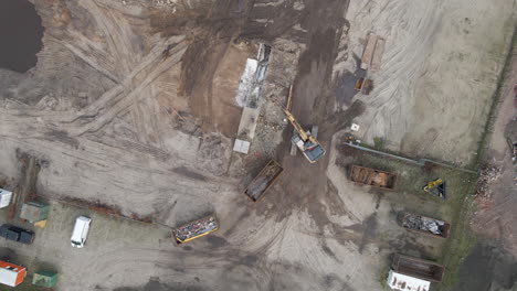 Top-down-aerial-of-excavator-collecting-rubble-from-demolished-building