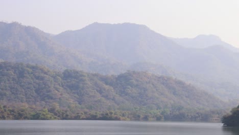 Neblige-Berglandschaft-Mit-Unberührtem-See-Am-Tag-Aus-Flachem-Winkel