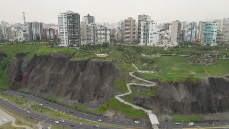 from urban heights to coastal beauty: drone unveils miraflores' buildings, widens to reveal the highway and ocean waves