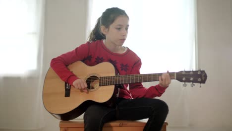 young girl playing guitar and singing