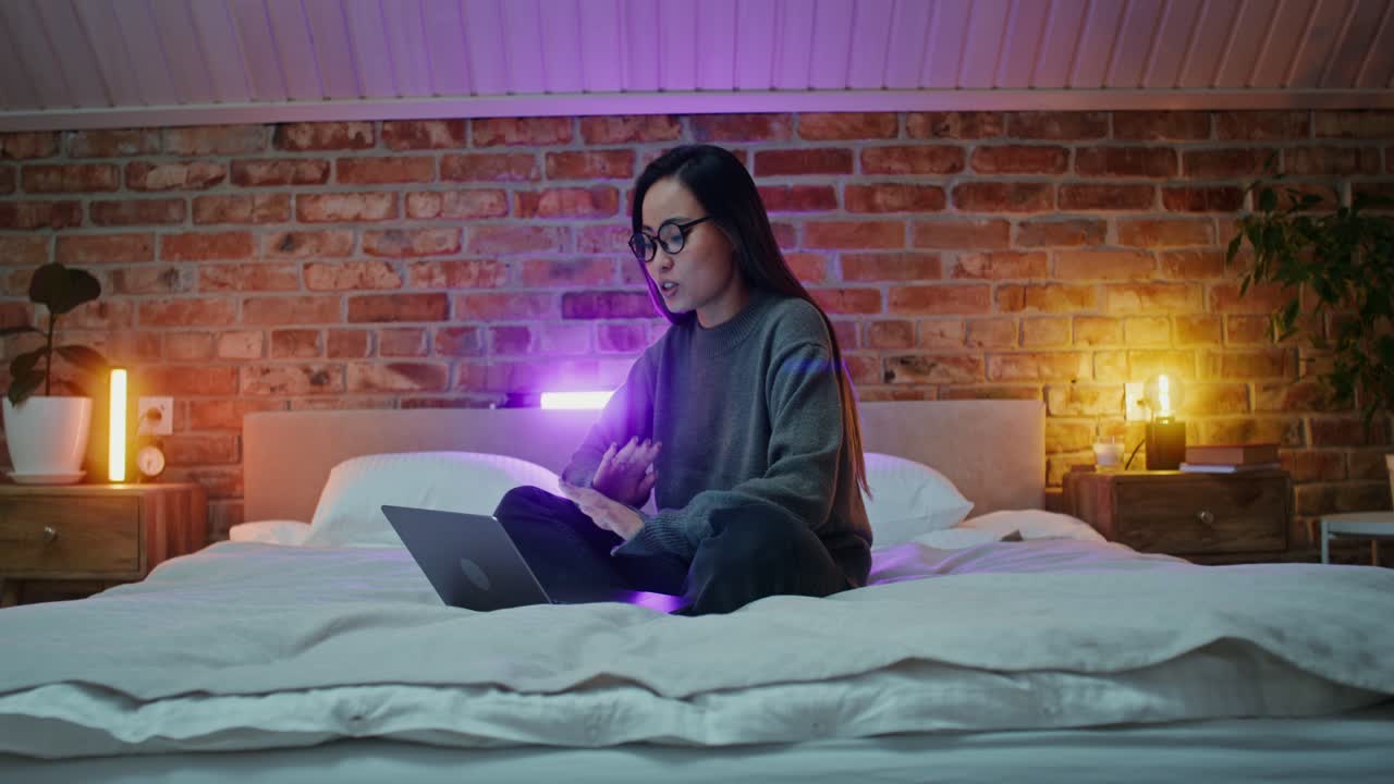 여자 는 침실 에서 노트북 을 사용 하고 있다