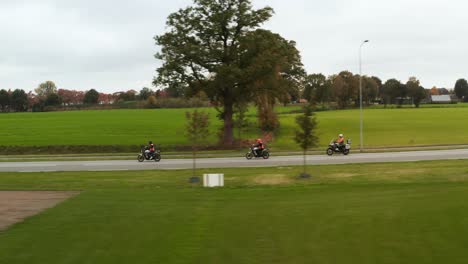 Drohnenansicht,-Die-Motorrädern-Zwischen-Grünen-Grasfeldern-Folgt