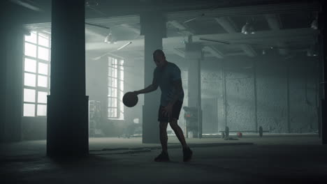 basketball player training in sport club. sporty man dribbling ball between legs